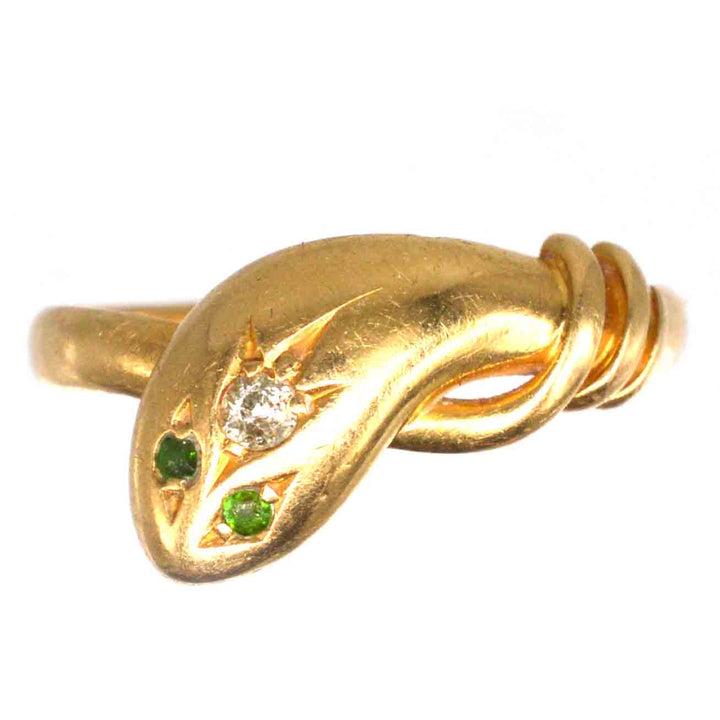 Edwardian 18ct gold snake ring with diamond and green garnet eyes, showcasing intricate craftsmanship.