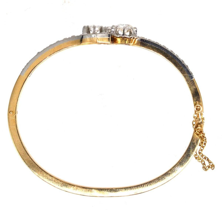 French early 20th century 18ct gold and platinum Toi et Moi diamond bangle with elegant detailing.