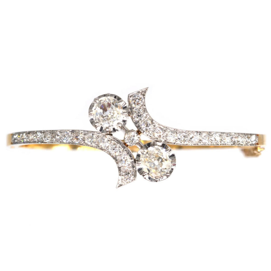 French early 20th century 18ct gold and platinum Toi et Moi diamond bangle, featuring two stunning diamonds.