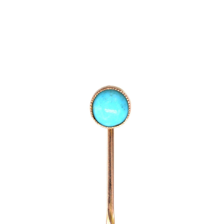 Edwardian 9ct gold tie pin featuring a vibrant turquoise stone in a classic millegrain setting.